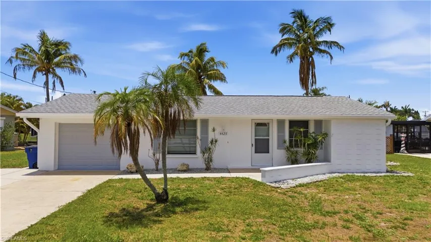 White exterior residence with a light gray garage door, featuring a gray shingle roof