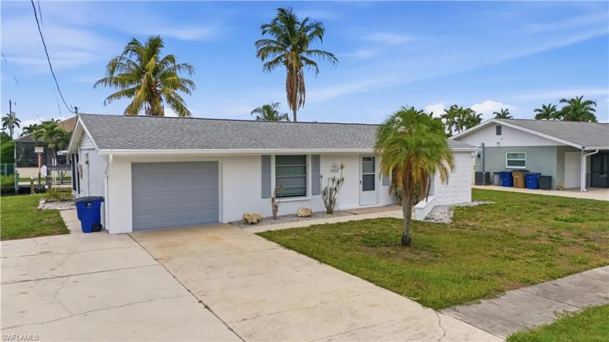 White single-story residence featuring a gray shingle roof, attached garage with a gray door, and a concrete driveway