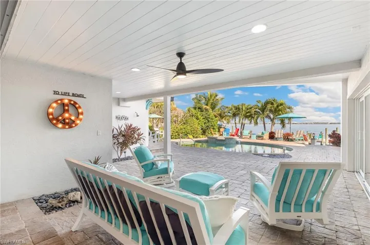 View of patio / terrace with a ceiling fan and a pool with connected hot tub