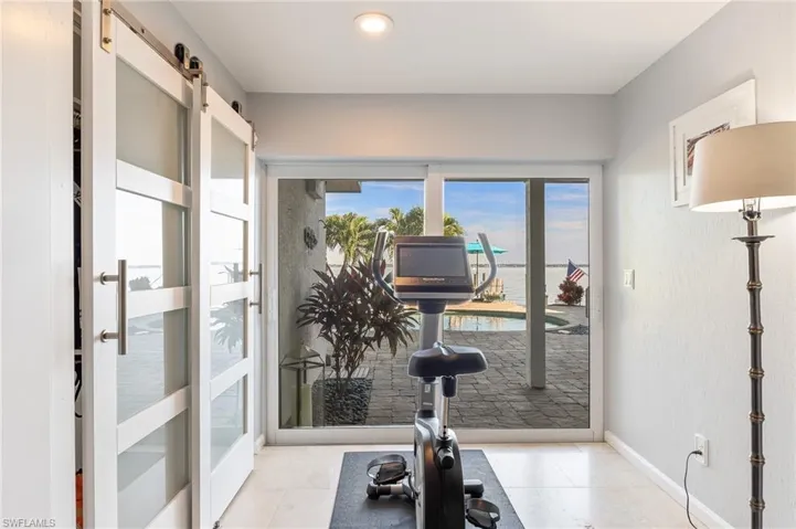 Exercise area with a barn door and light tile patterned floors