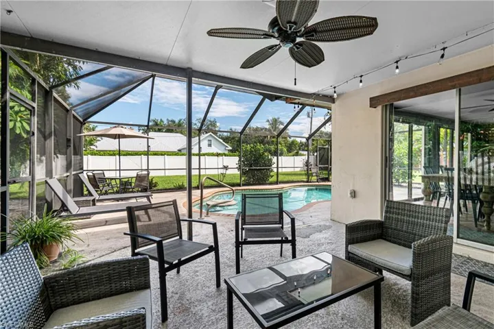 View of patio / terrace with ceiling fan, a fenced in pool, and glass enclosure