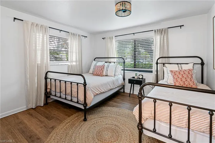 Bedroom featuring dark hardwood / wood-style floors and multiple windows