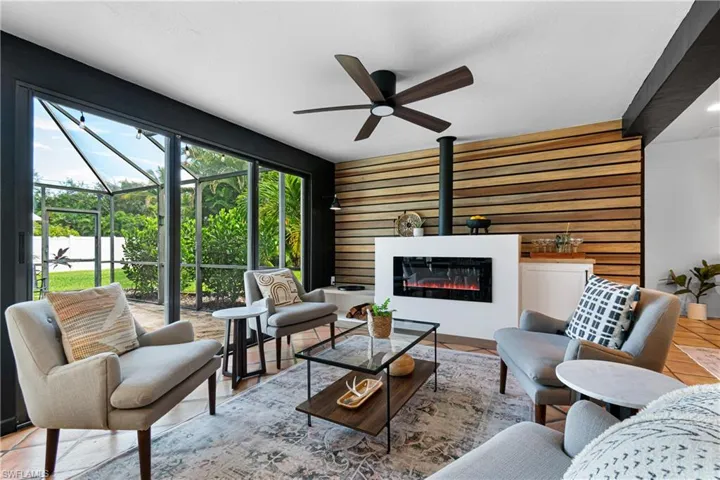 Living room featuring light tile patterned floors and ceiling fan