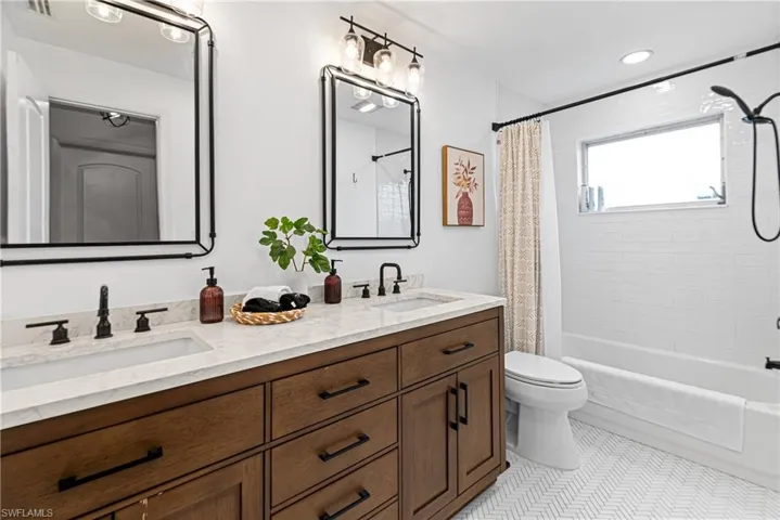 Full bathroom with tile patterned flooring, shower / bath combo, vanity, and toilet