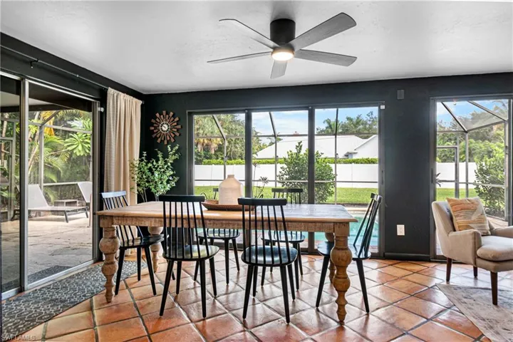 Tiled dining room featuring ceiling fan and a healthy amount of sunlight