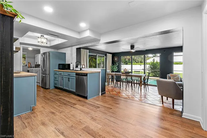 Kitchen featuring light hardwood / wood-style flooring, stainless steel appliances, ceiling fan, and blue cabinetry