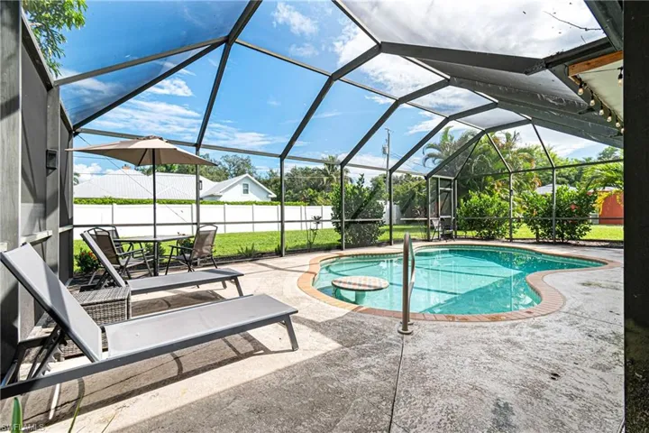 View of pool featuring glass enclosure and a patio area