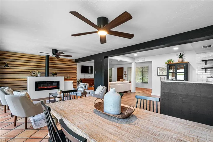 Dining room featuring beam ceiling, ceiling fan, light tile patterned flooring, and a textured ceiling