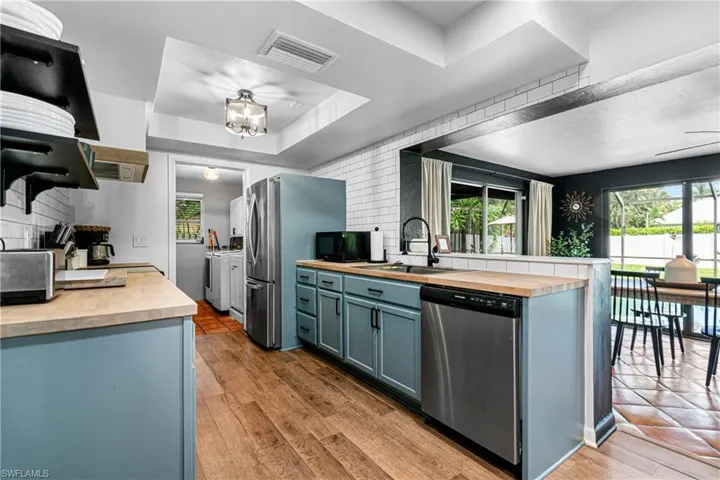 Kitchen featuring butcher block countertops, appliances with stainless steel finishes, and plenty of natural light