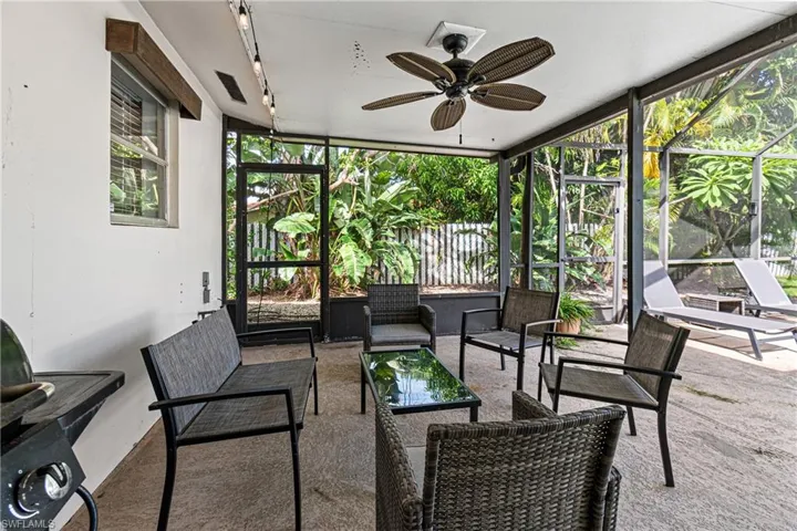 Sunroom / solarium featuring rail lighting and ceiling fan