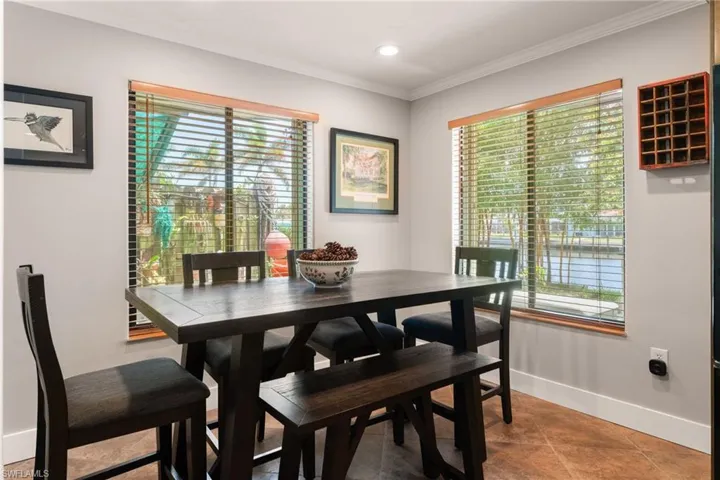 Tiled dining room featuring ornamental molding and recessed lighting