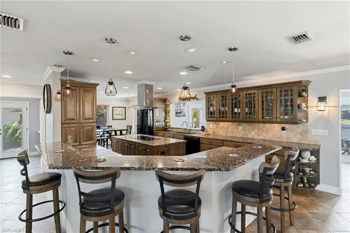 Kitchen featuring ornamental molding, plenty of natural light, tile patterned floors, backsplash, and recessed lighting