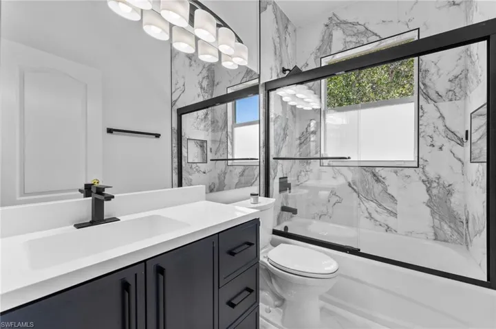 2024 Updated bathroom with new vanity, porcelain floor & wall tile plus new lighting and toilet