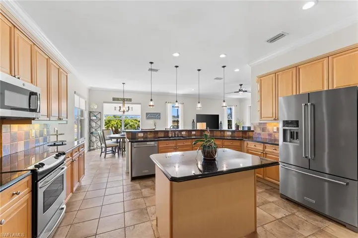 Expansive kitchen with Tile floors, Stainless GE Profile Microwave, Stainless GE Profile Stove, and Stainless Kitchen Aid Refrigerator & Dishwasher.