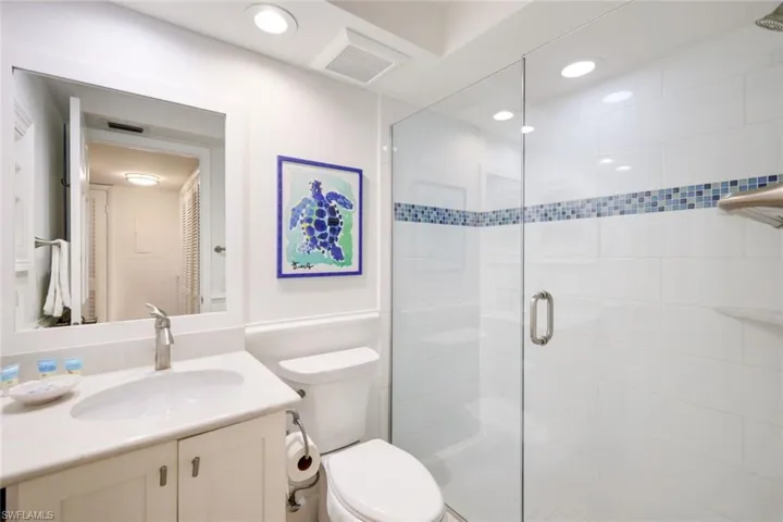 Bathroom with vanity, toilet, and a shower with shower door