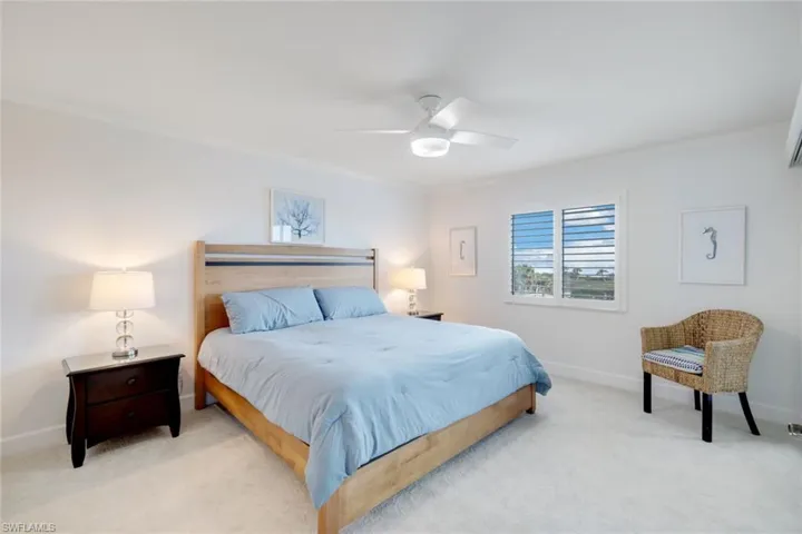 Bedroom with light colored carpet, ceiling fan, and crown molding