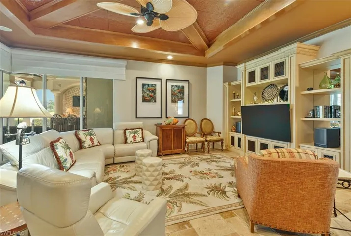 Living room featuring ornamental molding, ceiling fan, and built in features