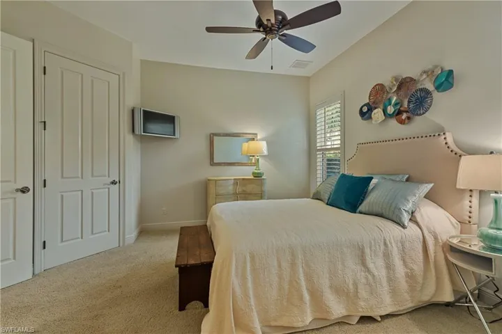 Bedroom with ceiling fan and light colored carpet