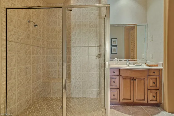 Bathroom featuring tile patterned floors, an enclosed shower, and vanity