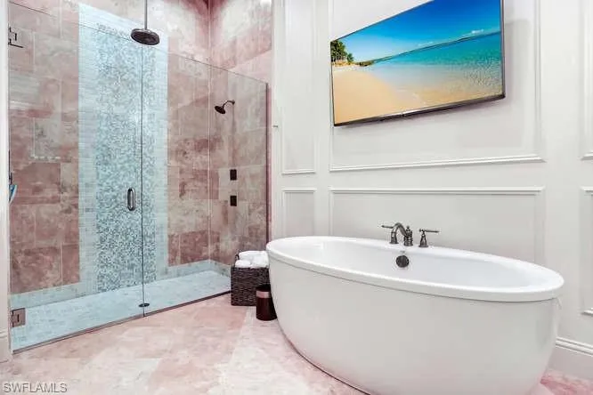 Bathroom with shower with separate bathtub and tile patterned floors