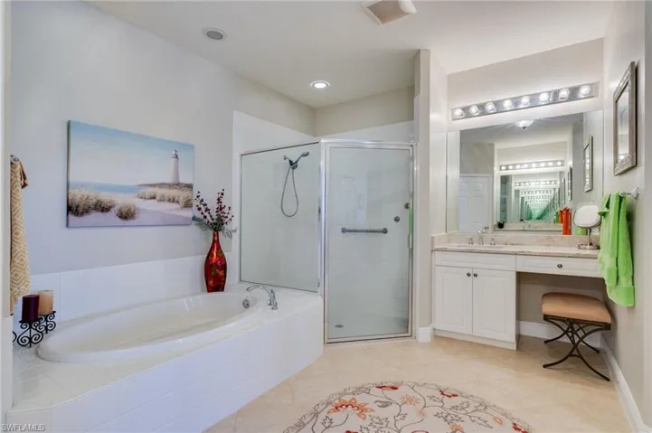 Bathroom with vanity, a shower stall, a bath, and light tile patterned floors