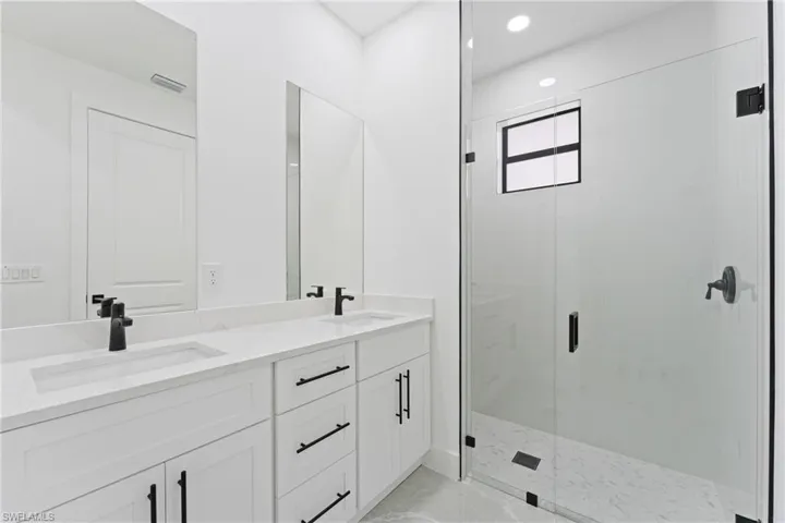 Bathroom with vanity and a shower with shower door