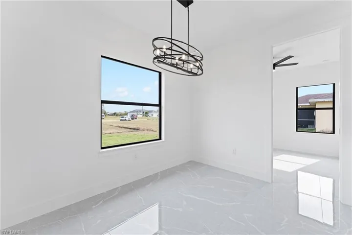 Unfurnished dining area featuring ceiling fan with notable chandelier