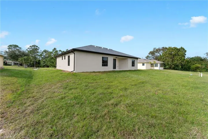 Back of house with a lawn