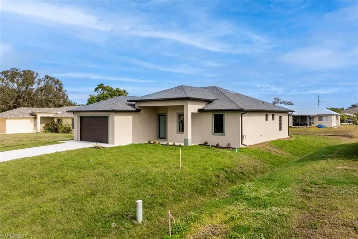 View of front of house with a garage and a front lawn