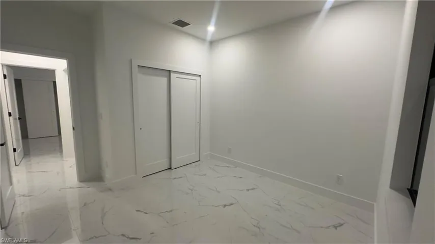 Unfurnished bedroom featuring a closet and light tile floors