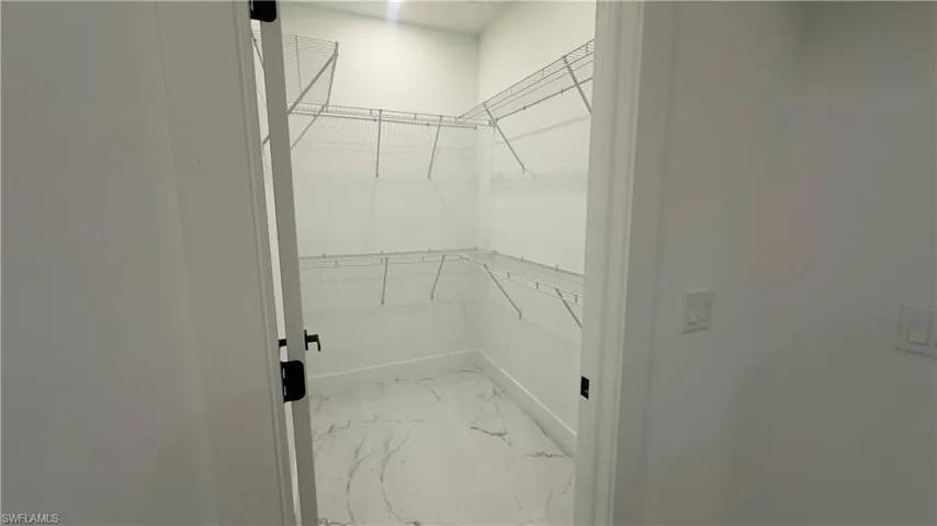 Spacious closet featuring light tile floors