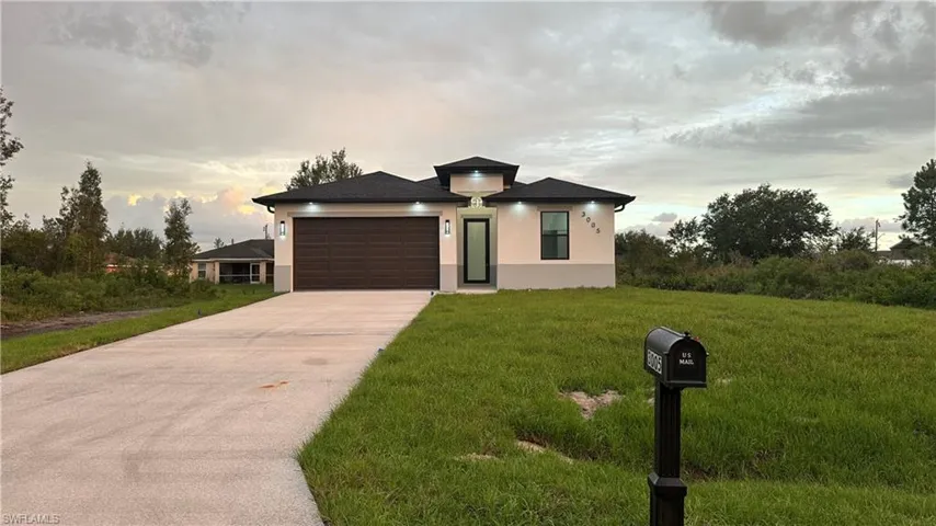 Prairie-style home featuring a garage and a lawn