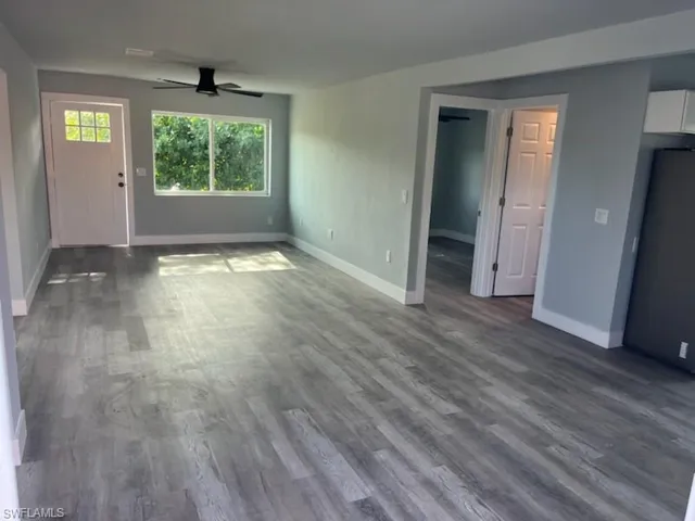 Unfurnished living room with ceiling fan and wood-type flooring