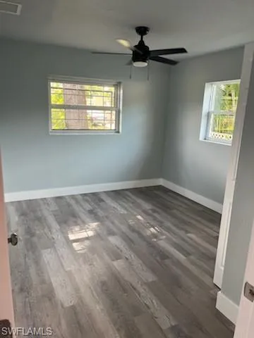 Spare room featuring ceiling fan and dark hardwood / wood-style flooring