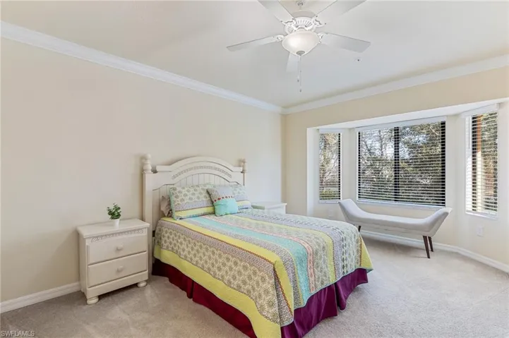 Comfortable, peaceful primary bedroom with carpet, big window, walk-in closet.
