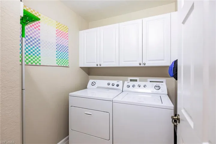 Laundry room featuring cabinets and washing machine and dryer