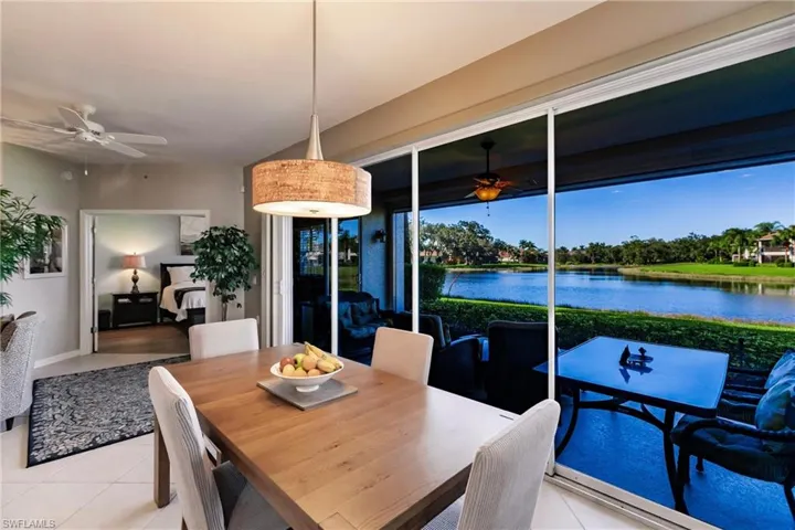 Tiled dining room featuring ceiling fan and a water view