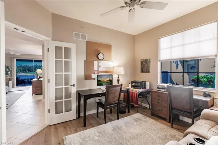 Home office with light hardwood / wood-style flooring and ceiling fan