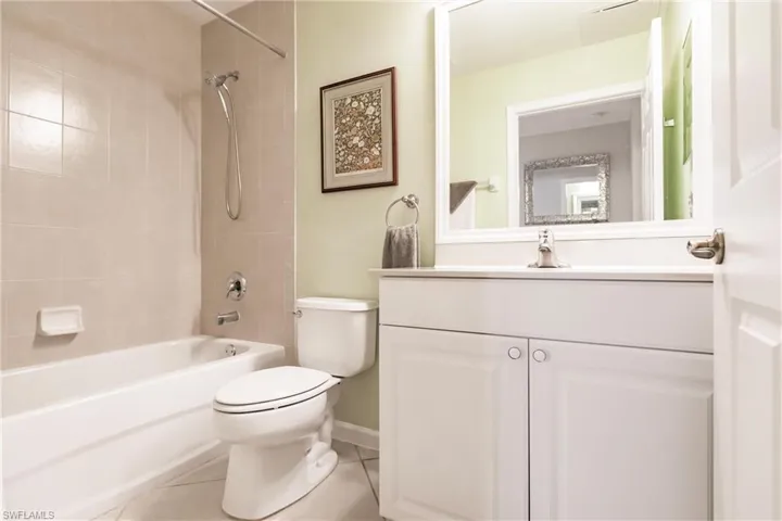 Full bathroom featuring tile patterned floors, tiled shower / bath combo, toilet, and vanity