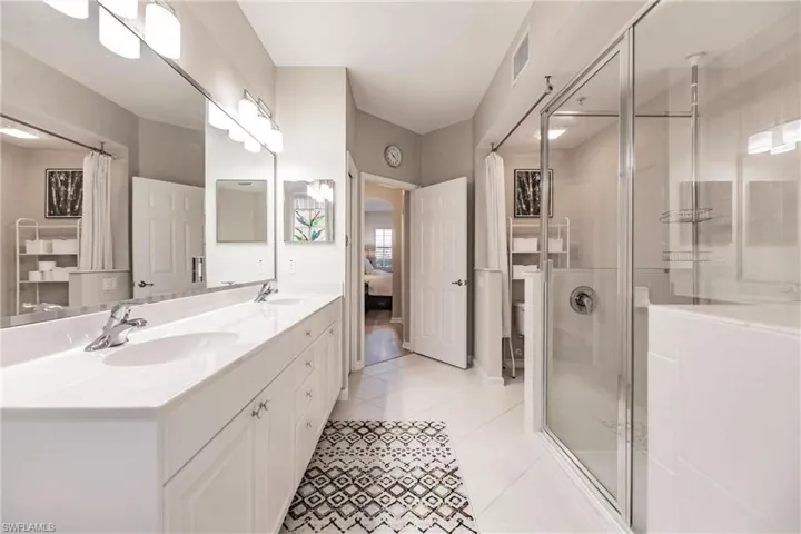 Bathroom featuring tile patterned flooring, vanity, and walk in shower