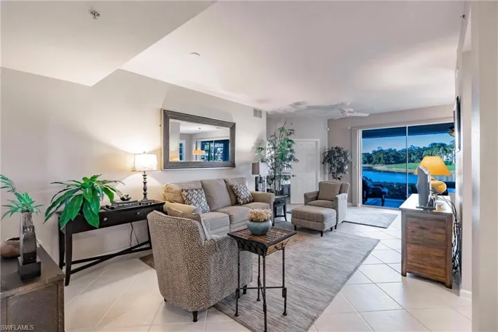 Living room with ceiling fan and light tile patterned flooring