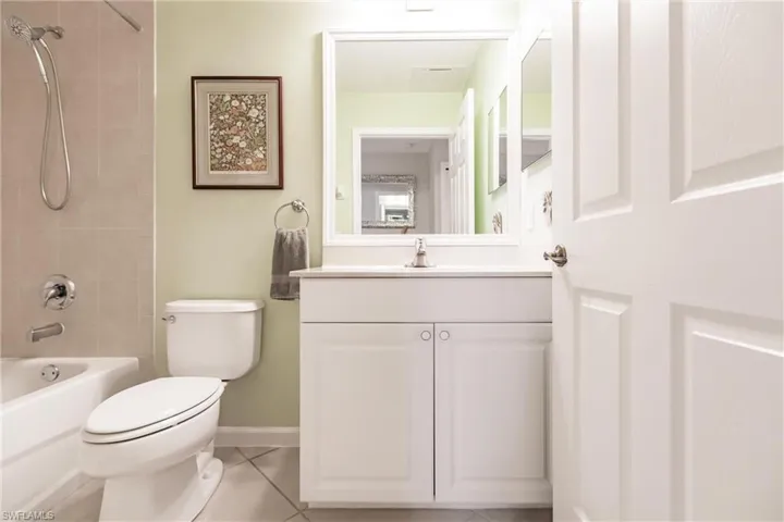 Full bathroom with tiled shower / bath, tile patterned flooring, vanity, and toilet