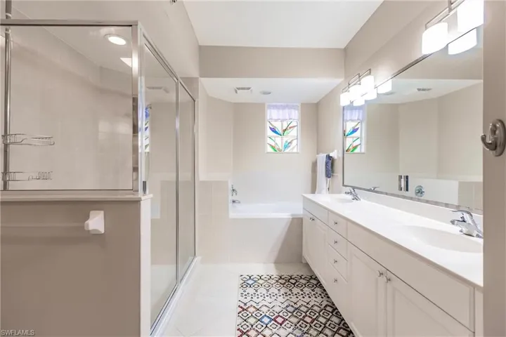 Bathroom with tile patterned floors, separate shower and tub, and vanity