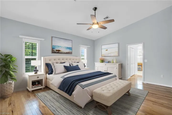 *Virtually Staged* Bedroom featuring lofted ceiling, connected bathroom, light hardwood / wood-style flooring, and ceiling fan