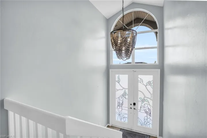 Foyer with a notable chandelier, lofted ceiling, and french doors