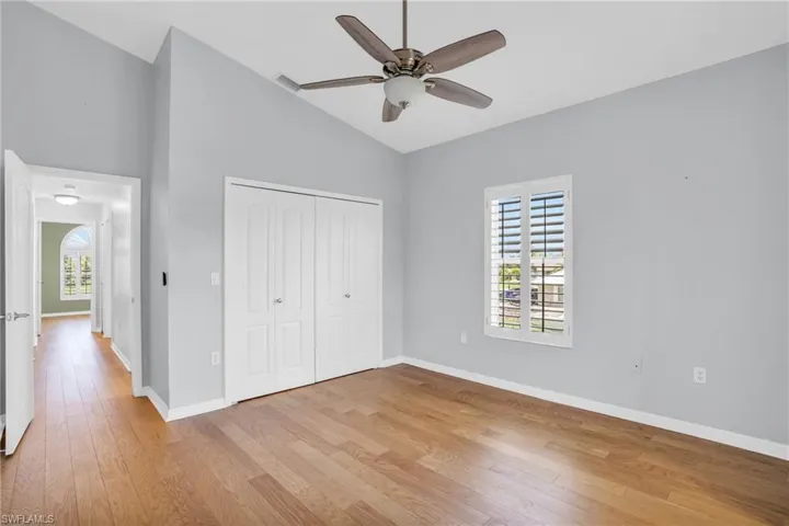 Unfurnished bedroom featuring high vaulted ceiling, a closet, light wood-type flooring, and ceiling fan