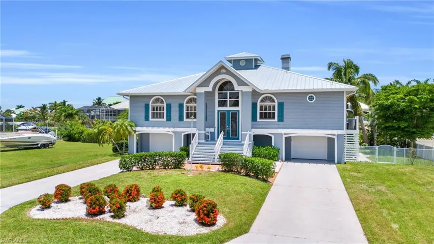View of front of property featuring a garage and a front lawn