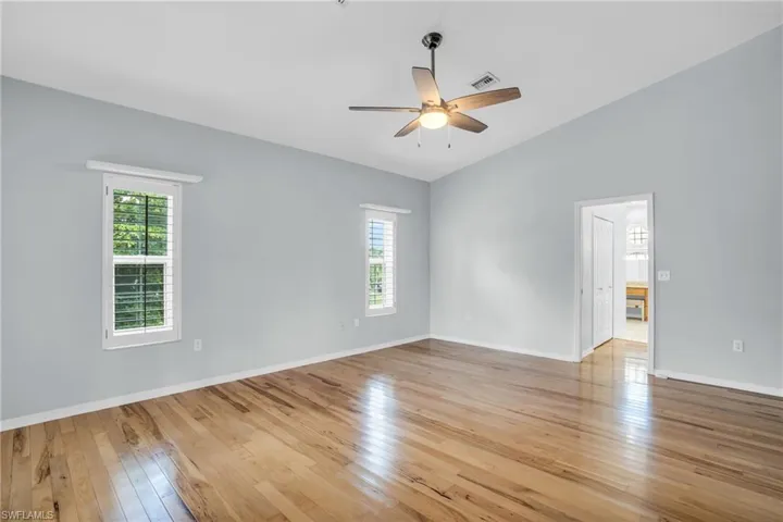 Unfurnished room with light wood-type flooring, ceiling fan, and lofted ceiling