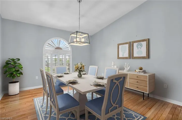 *Virtually Staged* Dining area featuring light hardwood / wood-style flooring, an inviting chandelier, and vaulted ceiling