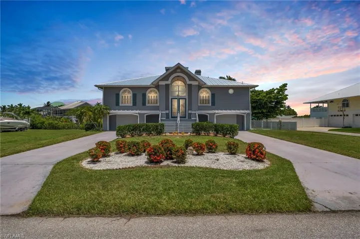 View of front of property with a garage and a yard